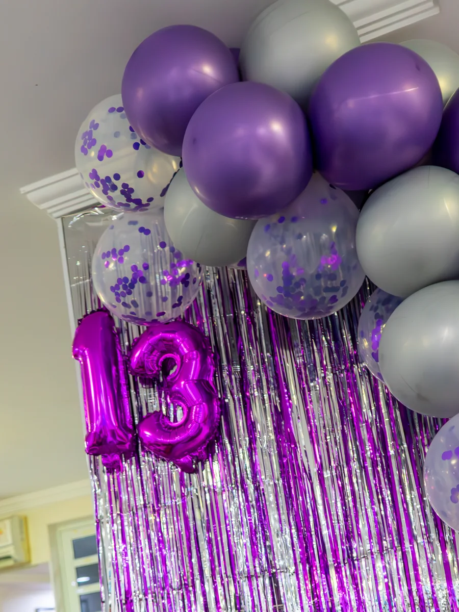 Decoração de balões roxo e prata com cortina metalizada