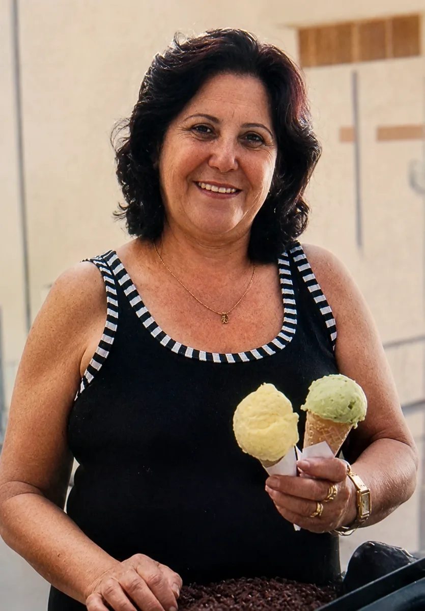 Dona Marli sorrindo com duas casquinhas de sorvete